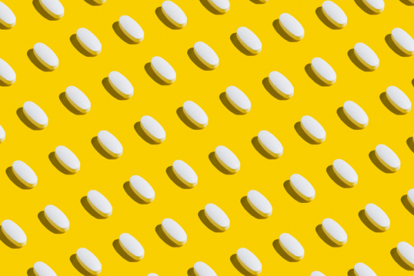 Small white, oval pills diagonally spaced on a yellow background; concept is antidepressant medications